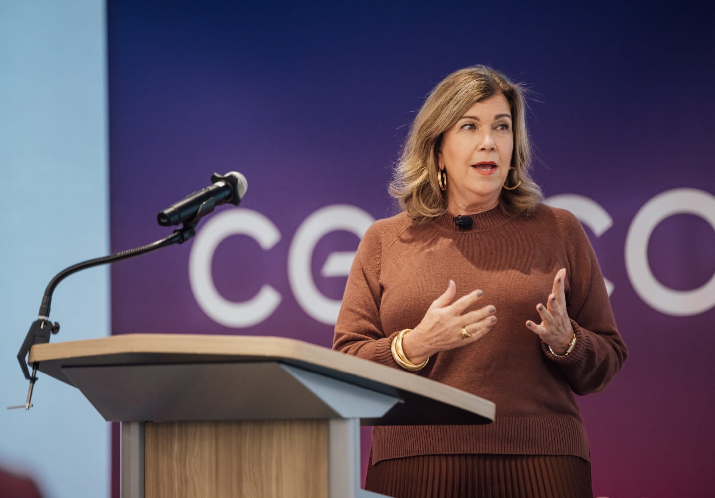 Gina K. Clark, the Executive Vice President and Chief Communications and Administration Officer of Cencora, speaking at a podium during a corporate event.