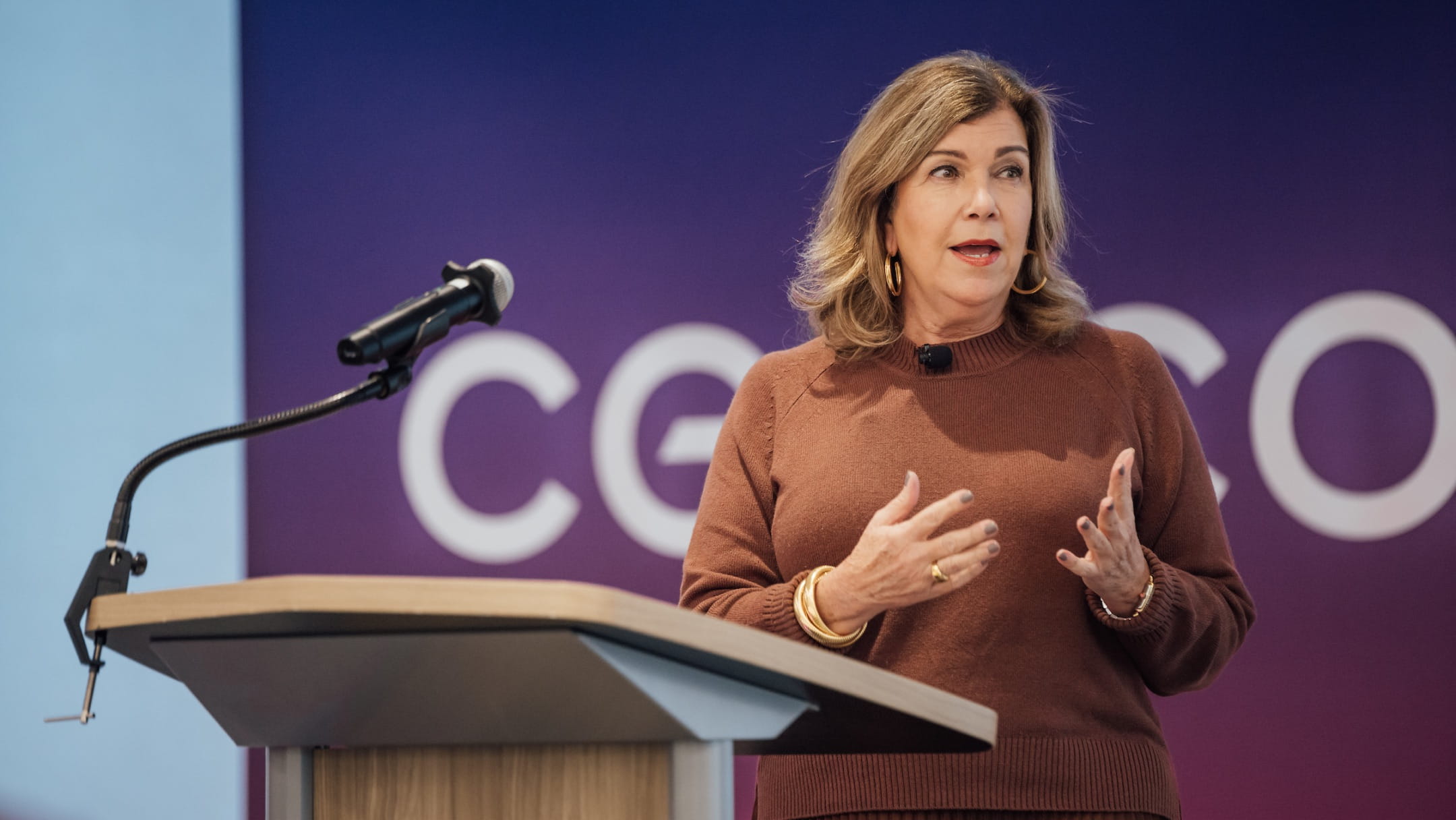 Gina K. Clark, the Executive Vice President and Chief Communications and Administration Officer of Cencora, speaking at a podium during a corporate event.