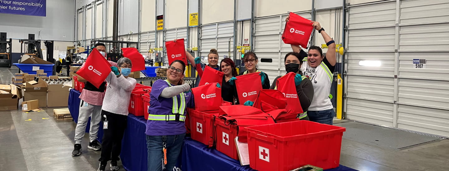 Eight Cencora employees in a warehouse packing hygiene kits for military veterans that were distributed in local communities through our Red Cross partnership.